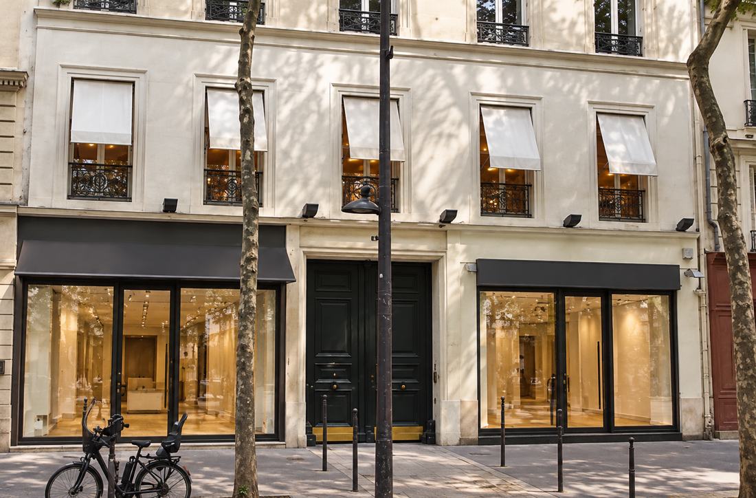 Deux boutiques vitrées sous un immeuble clair à balcons